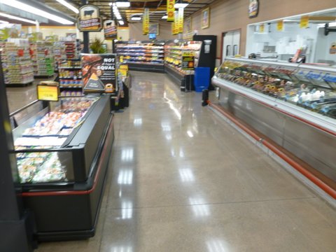 Concrete flooring supports displays in the meat department of a grocery store.